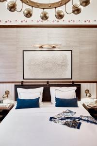 布达佩斯卡拉斯之家酒店的卧室配有带蓝色枕头的大型白色床