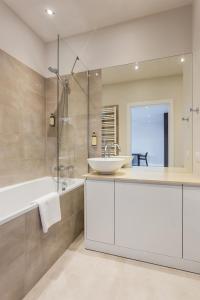 华沙莫克托夫铂金住宅公寓的浴室配有白色水槽、浴缸和浴缸。