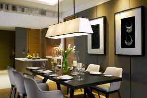 清迈Anantara Chiang Mai Serviced Suites的一间用餐室,配有黑色的桌子和椅子