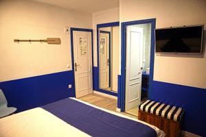 布拉内斯米兰达旅馆 的一间带蓝色墙壁、一张床和电视的卧室