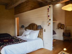 Noron-la-PoterieLe Manoir du Pont Senot的卧室配有白色的床和木墙