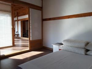 庆州耶陶尔韩屋旅馆的一间卧室设有一张床和一个大窗户