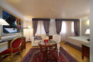 威尼斯利亚斯迪皇宫酒店的酒店客房设有一张床铺、一张桌子和一间卧室。