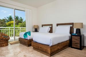 南凯科斯Sailrock South Caicos - Island Hop Flight Included的一间卧室设有一张床和一个阳台
