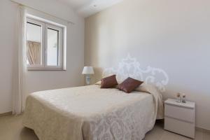 奥斯图尼Perla di Ostuni by BarbarHouse的白色的卧室设有一张大床和一个窗户
