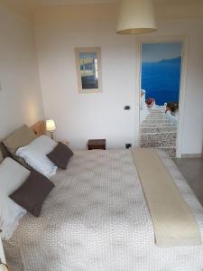 阿纳卡普里B&B Il Tramonto的卧室内的一张大床,享有海景