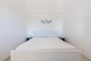 奥斯图尼La Murreddina by BarbarHouse的白色墙壁的房间里一张白色的床