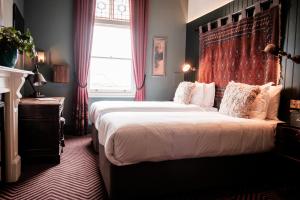 伦敦半月酒店的一间卧室设有一张大床和一个窗户。