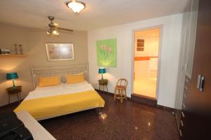 阿尔卡拉Casa Lodge Finca Alcalá的一间卧室配有一张带黄色床单的床和推拉门。