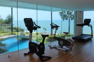 北芭堤雅芭提雅棕榈滩旺马特公寓的享有游泳池景致的健身房和健身自行车