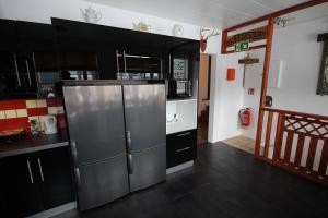 格仑达积图哈玛拉赫9号住宿加早餐旅馆的厨房配有黑色橱柜和不锈钢冰箱