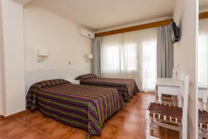 贝纳尔马德纳索勒米尔旅馆的酒店客房设有两张床和一张桌子。