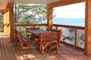 尤克卢利特Melfort Bell Guest Suites的门廊上的木桌和椅子,享有海景