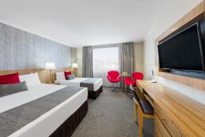 布里斯班Hotel Diana的酒店客房设有两张床和一台平面电视。