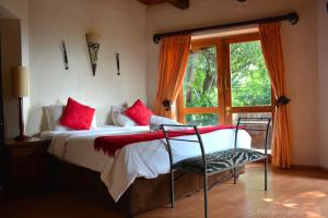 哈特比斯普特蒙塔格旅馆的一间卧室配有一张带红色枕头的床和一扇窗户