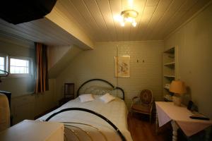 迪克斯梅德B&B House Caesekin的一间卧室配有一张床、一张桌子和一盏灯
