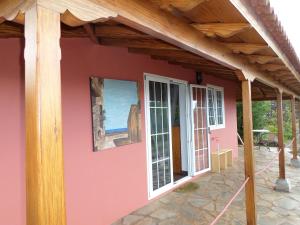 蓬塔戈尔达Casa Bellavista的粉红色的房屋,设有木屋顶