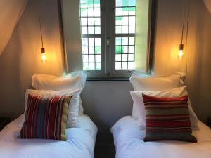 根特伯格大街8号旅馆的带窗户的客房内的两张床和枕头
