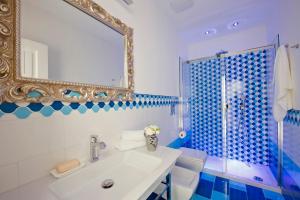 阿马尔菲瓦尔费里尔旅馆的蓝色和白色的浴室设有水槽和镜子