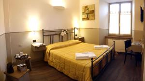 诺尔恰Albergo Benito的一间卧室配有一张带黄色床单的床和一扇窗户。