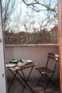 塞格德Szamóca Apartman的阳台配有桌椅和窗户