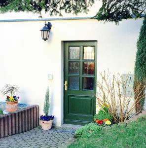 萨克森自由州诺伊斯塔滕Ferienwohnung Ulbrich的白色房子上一扇绿门,花朵繁多
