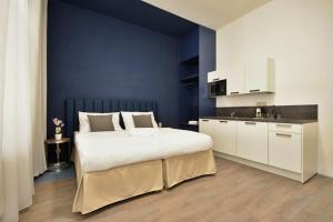 布拉格阿尔维奥套房酒店的一间卧室设有一张大床和蓝色的墙壁
