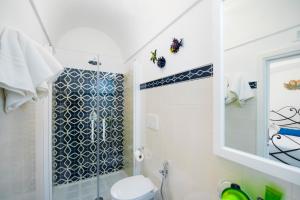 波西塔诺Exclusive Apartments Positano的带淋浴、卫生间和盥洗盆的浴室