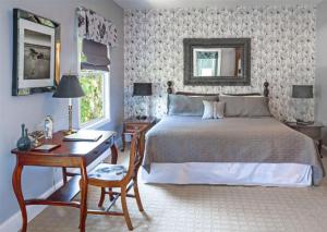 罗斯西影子草坪客栈的一间卧室配有一张床和一张书桌,铺有四柱床。