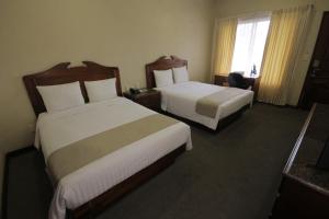 坦皮科圣安东尼奥酒店的酒店客房设有两张床和窗户。