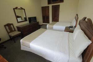 坦皮科圣安东尼奥酒店的一间卧室配有两张床、一张桌子和一面镜子