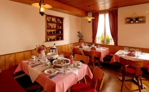 因特拉肯美地经济酒店的用餐室配有带粉红色桌布的桌子
