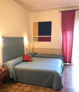 锡拉库扎斯卡拉格利卡酒店的一间卧室配有一张红色枕头的床