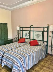 锡拉库扎斯卡拉格利卡酒店的一间卧室配有一张带两个红色枕头的床