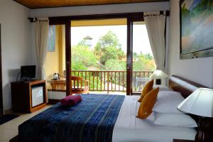 乌布扎缇3小屋及温泉酒店的一间卧室设有一张床,享有阳台的景色