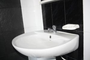 埃拉艾拉月光度假别墅的浴室设有黑色瓷砖,配有白色水槽。