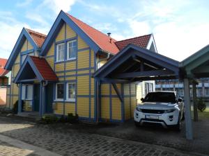 赖因斯贝格Ferienhaus Schoen的停在一个黄色和蓝色房子前面的卡车