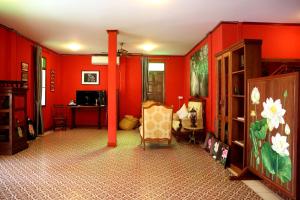 巴色花园酒店的客厅设有红色的墙壁和椅子