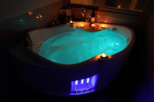 西归浦市济州海洋山庄度假屋的浴室内带灯的蓝色浴缸