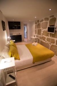 波尔图Historical Porto Studios的一间卧室设有一张大床和石墙