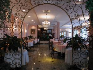 格拉多Hotel Eden的一间带桌椅和门的用餐室