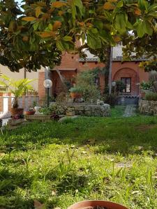 阿斯科利皮切诺阿斯科利皮切诺秘密花园酒店的一座有绿草和树的院子的房子