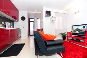 里斯本安娜设计公寓的客厅配有黑椅和电视