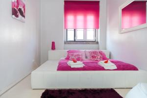里斯本安娜设计公寓的白色卧室配有粉红色的床和紫色毯子