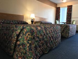 堪萨斯城堪萨斯城美国酒店，KS的酒店客房设有两张床和一张带台灯的桌子。