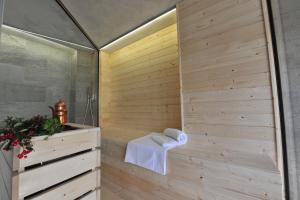 瓜热讷La Madernassa Resort - Casalora Dimora Storica di Charme的带淋浴的浴室和木墙