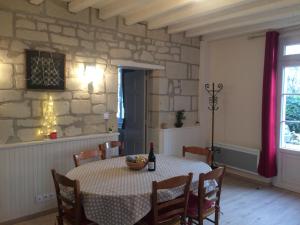 希农Domaine des Aubuis的一间设有桌子和石墙的用餐室