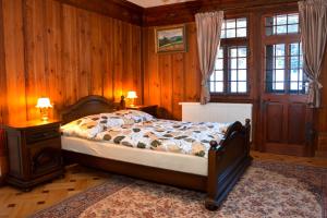 玛丽亚温泉Apartman Forstamt Glatzen Kladska的一间卧室设有一张床、木墙和窗户。