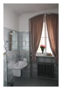 布拉格布拉格黄金时代酒店的一间带水槽和卫生间的浴室以及窗户。