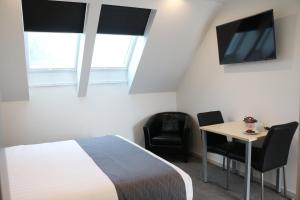 基督城基督城MCM汽车旅馆的一间卧室配有一张床、一张桌子和一台电视。